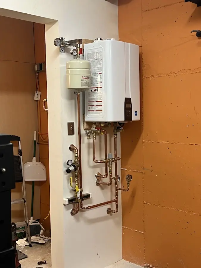Plumbing technician inspecting water heater connections in Bardstown